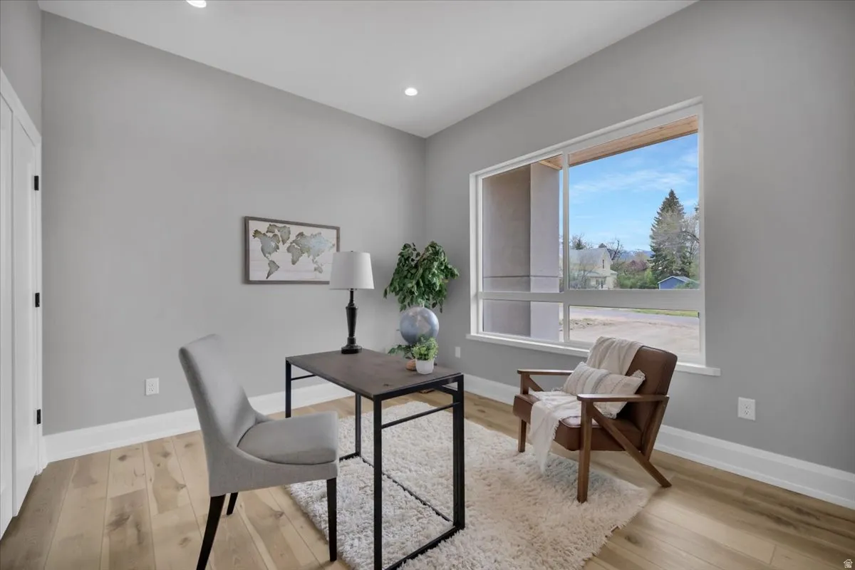 Home office with light wood-type flooring and recessed lighting