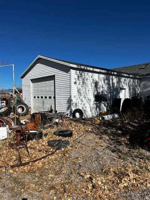 View of side of home featuring an outbuilding and a garage