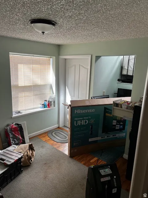 Bedroom featuring wood finished floors and a textured ceiling