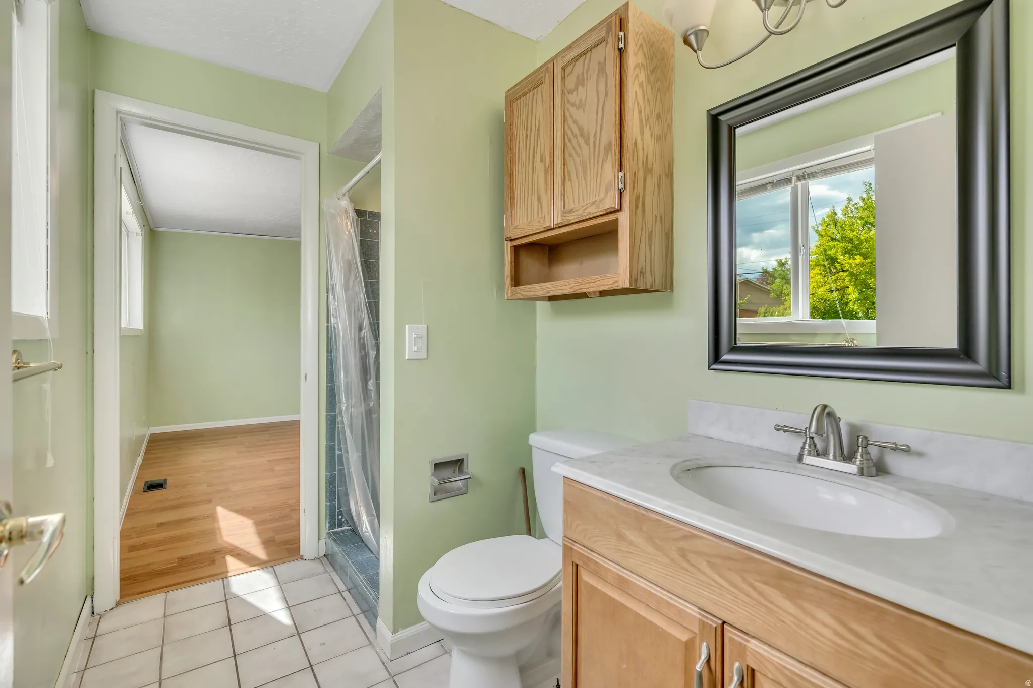 Bathroom with light tile patterned flooring, vanity, and a shower with curtain