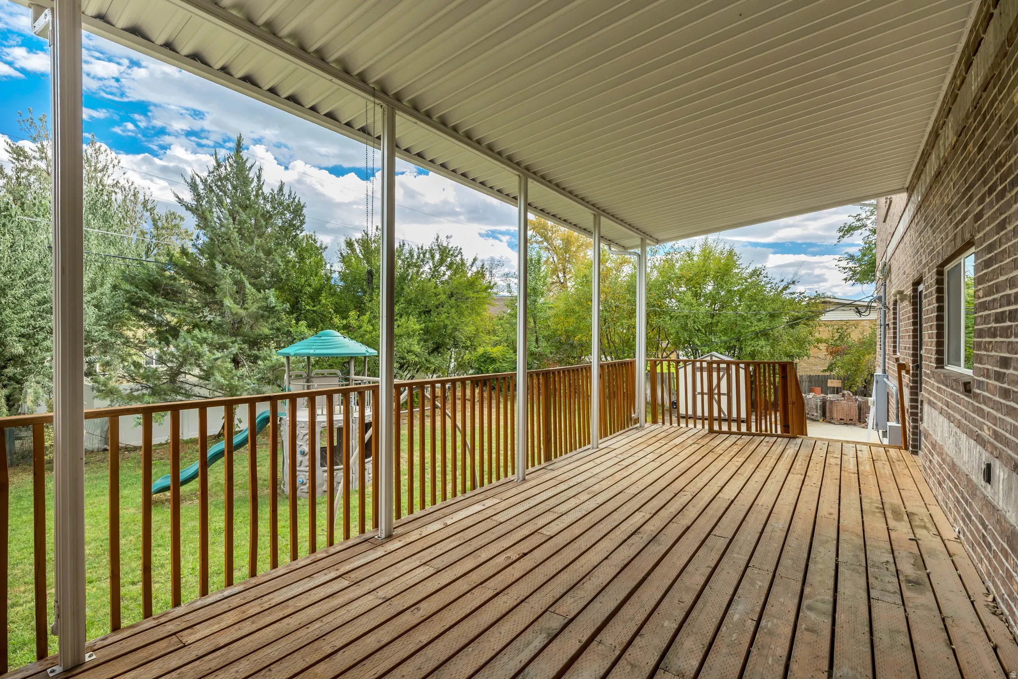 Deck with a playground and a yard