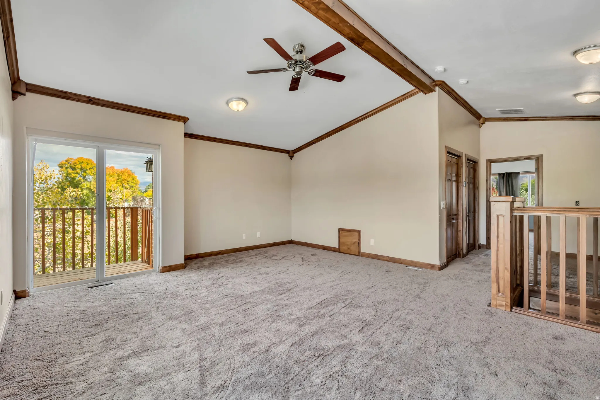 Unfurnished room featuring ornamental molding, a ceiling fan, and light carpet