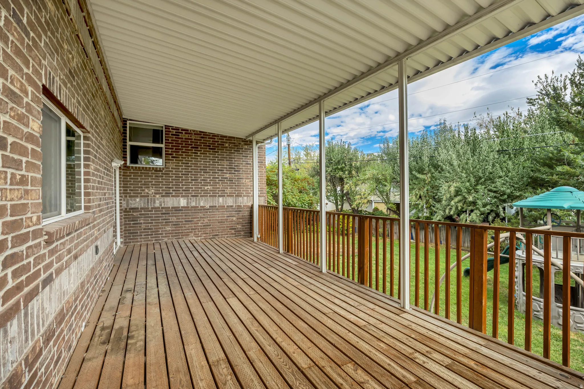Wooden terrace featuring a lawn