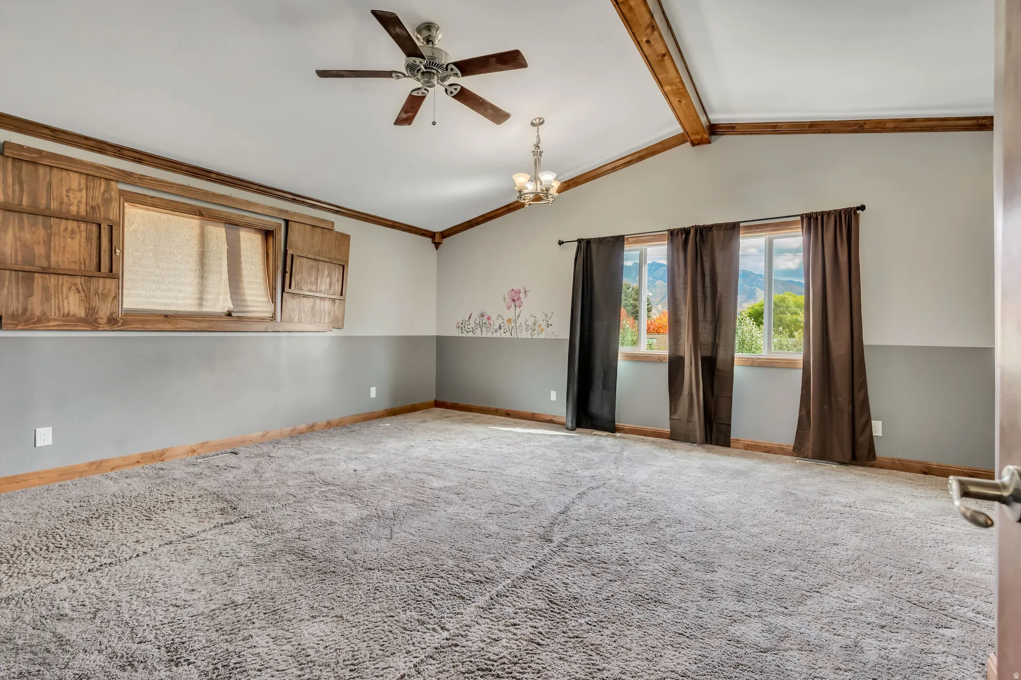 Unfurnished room with carpet, a ceiling fan, a chandelier, and ornamental molding