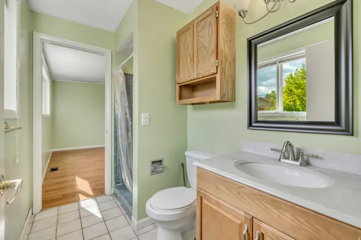 Bathroom with light tile patterned flooring, vanity, and a shower with curtain