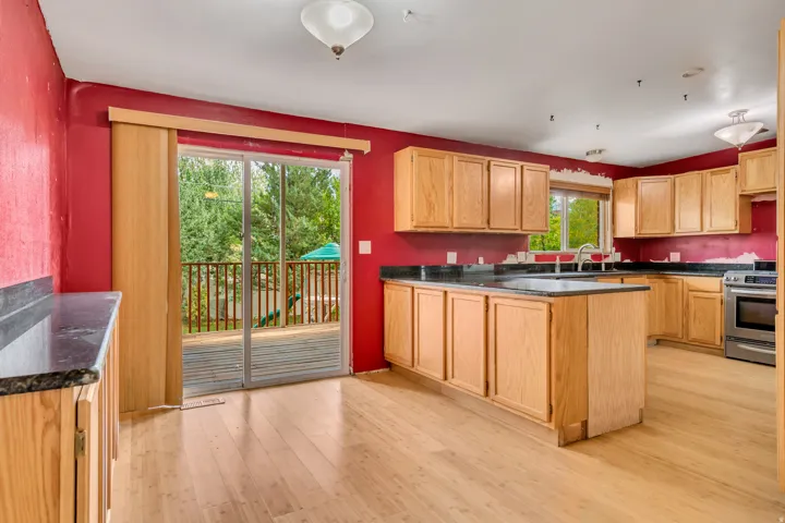 Kitchen with a peninsula, stainless steel range, light wood-style flooring, and light brown cabinets