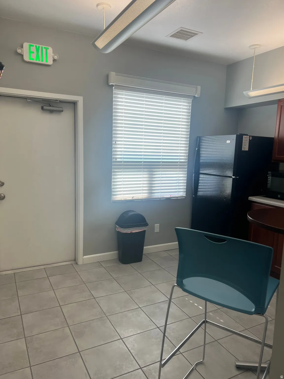 Kitchen featuring light countertops, decorative light fixtures, and black appliances