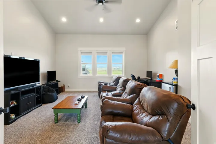 Media room with ceiling fan, a desk, and recessed lighting