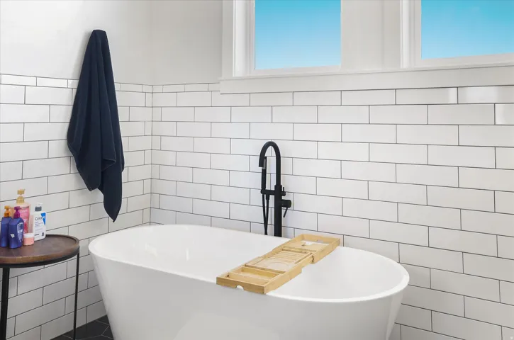 Full bathroom featuring tile walls and a freestanding bath