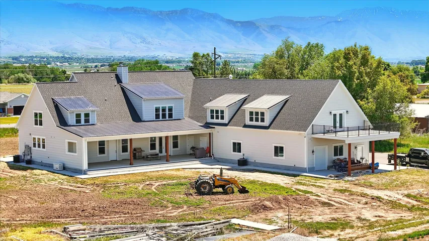 Back of house with a patio, a mountain view, a chimney, and a metal roof