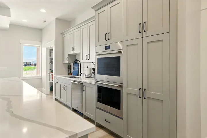 Prep-Kitchen featuring appliances with stainless steel finishes, light stone counters, recessed lighting, light wood-style floors, and gray cabinetry