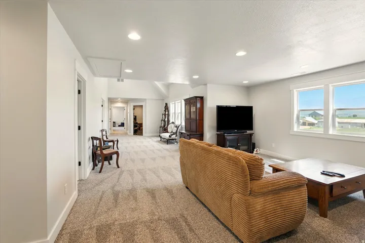 Carpeted living room with attic access and recessed lighting