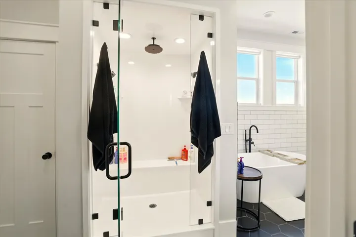 Bathroom with a freestanding tub, a shower stall, tile patterned flooring, and tile walls
