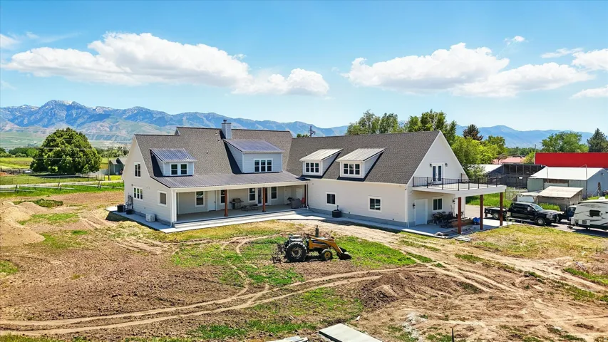 Back of property with a mountain view, a patio, and a chimney