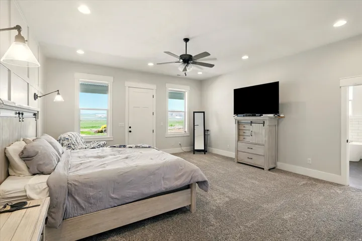 Carpeted bedroom with a ceiling fan, recessed lighting, and access to outside