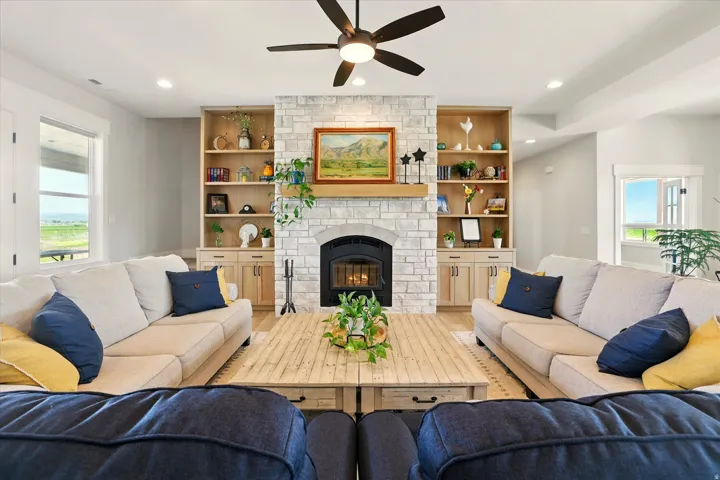 Living area featuring a fireplace, recessed lighting, a ceiling fan, and wood-style floors