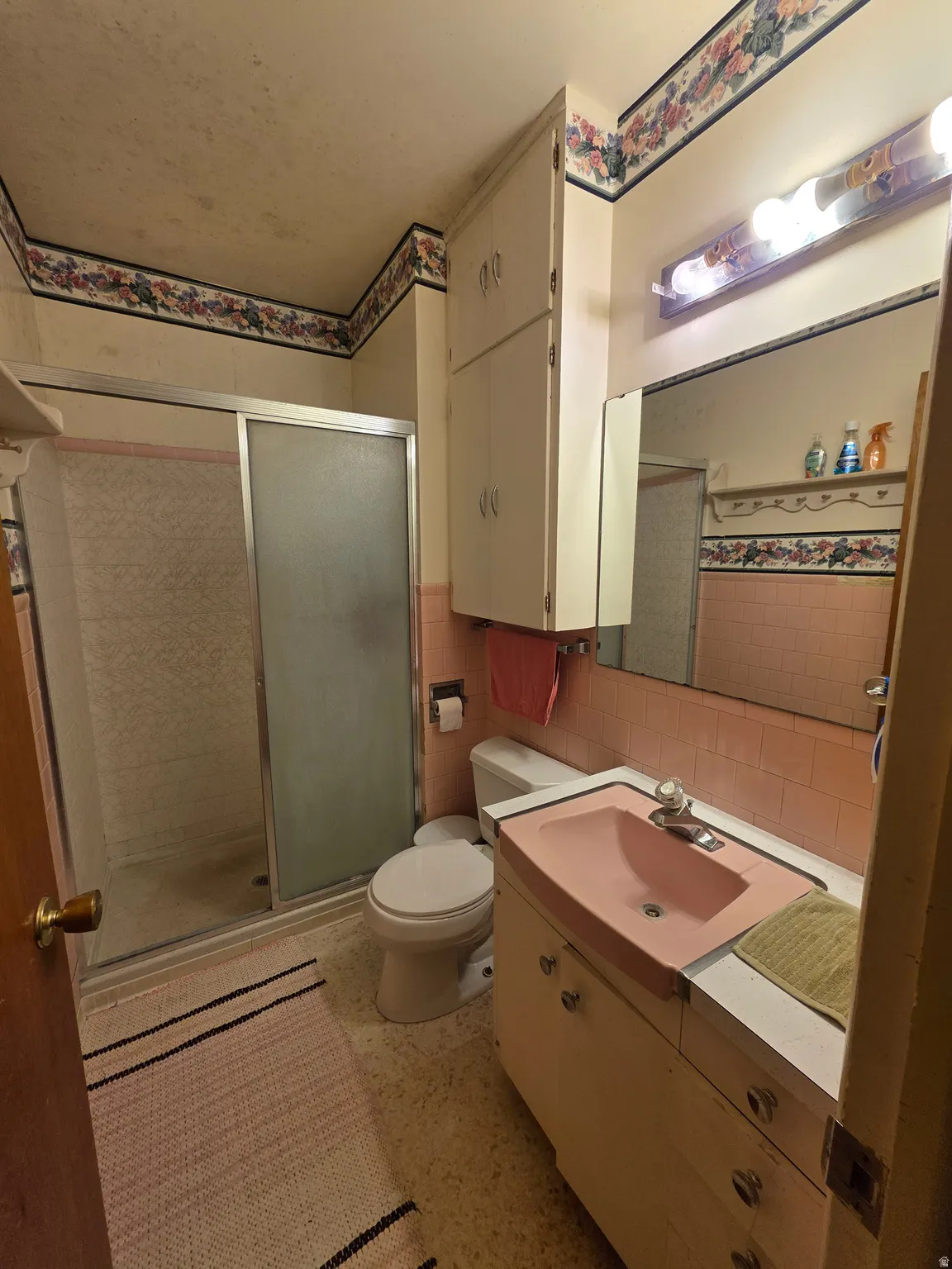 Full bathroom featuring vanity, tile walls, and a shower stall