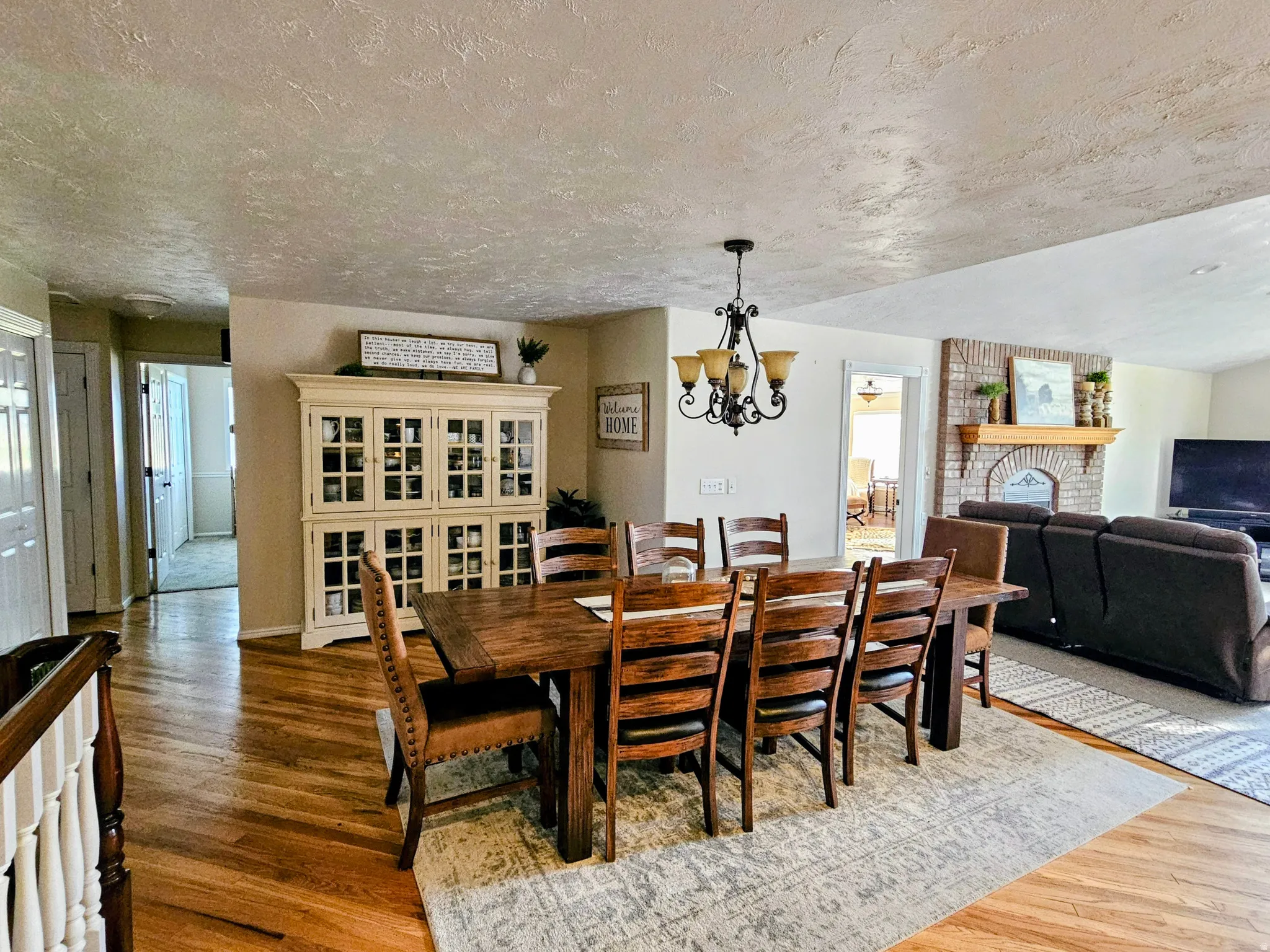 Dining space with a fireplace, plenty of natural light, dark wood finished floors, a textured ceiling, and a chandelier