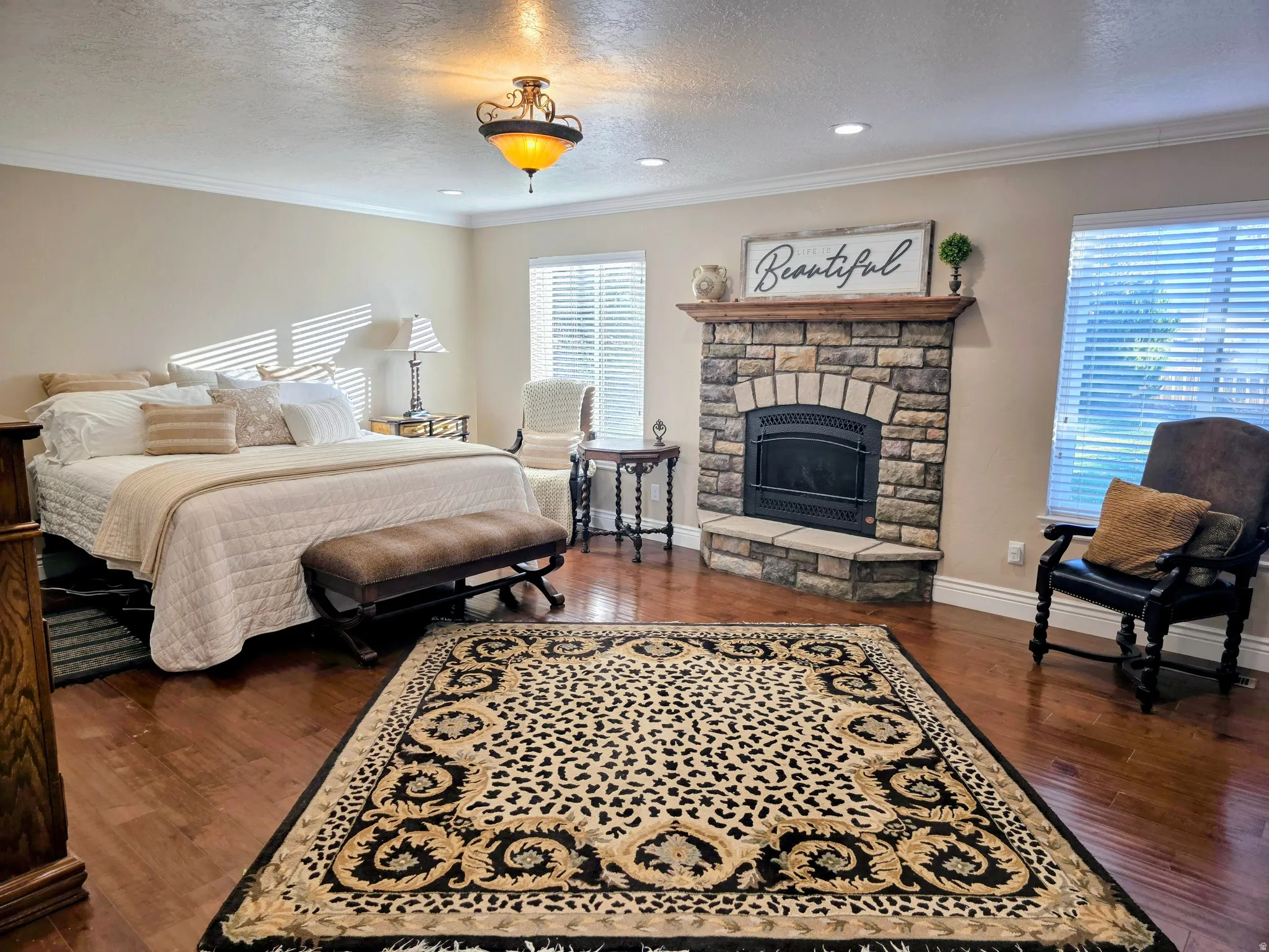 Bedroom featuring a textured ceiling, ornamental molding, a fireplace, dark wood-type flooring, and recessed lighting