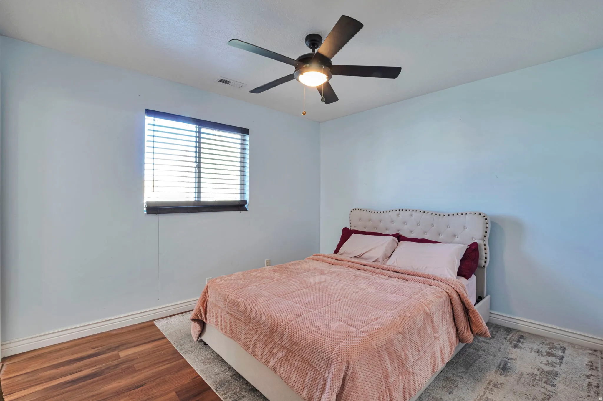 Bedroom featuring wood finished floors and a ceiling fan