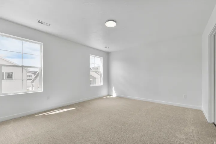 Unfurnished room with light colored carpet and a textured ceiling