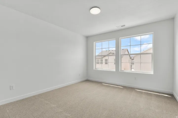 Spare room featuring carpet flooring and baseboards