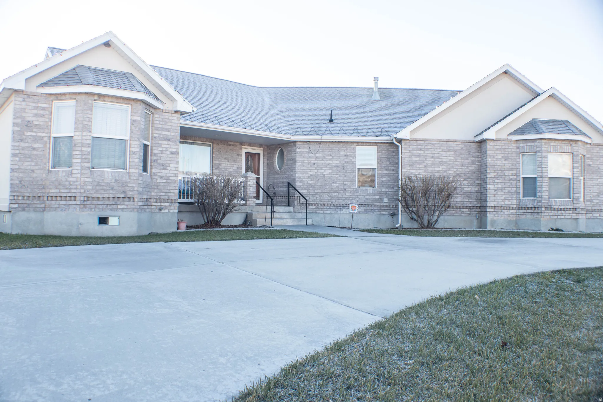 View of front of property with brick siding and a shingled roof