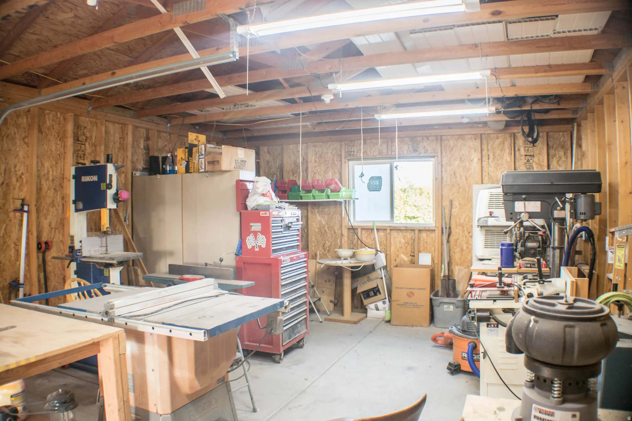 Basement featuring wooden walls and a workshop area