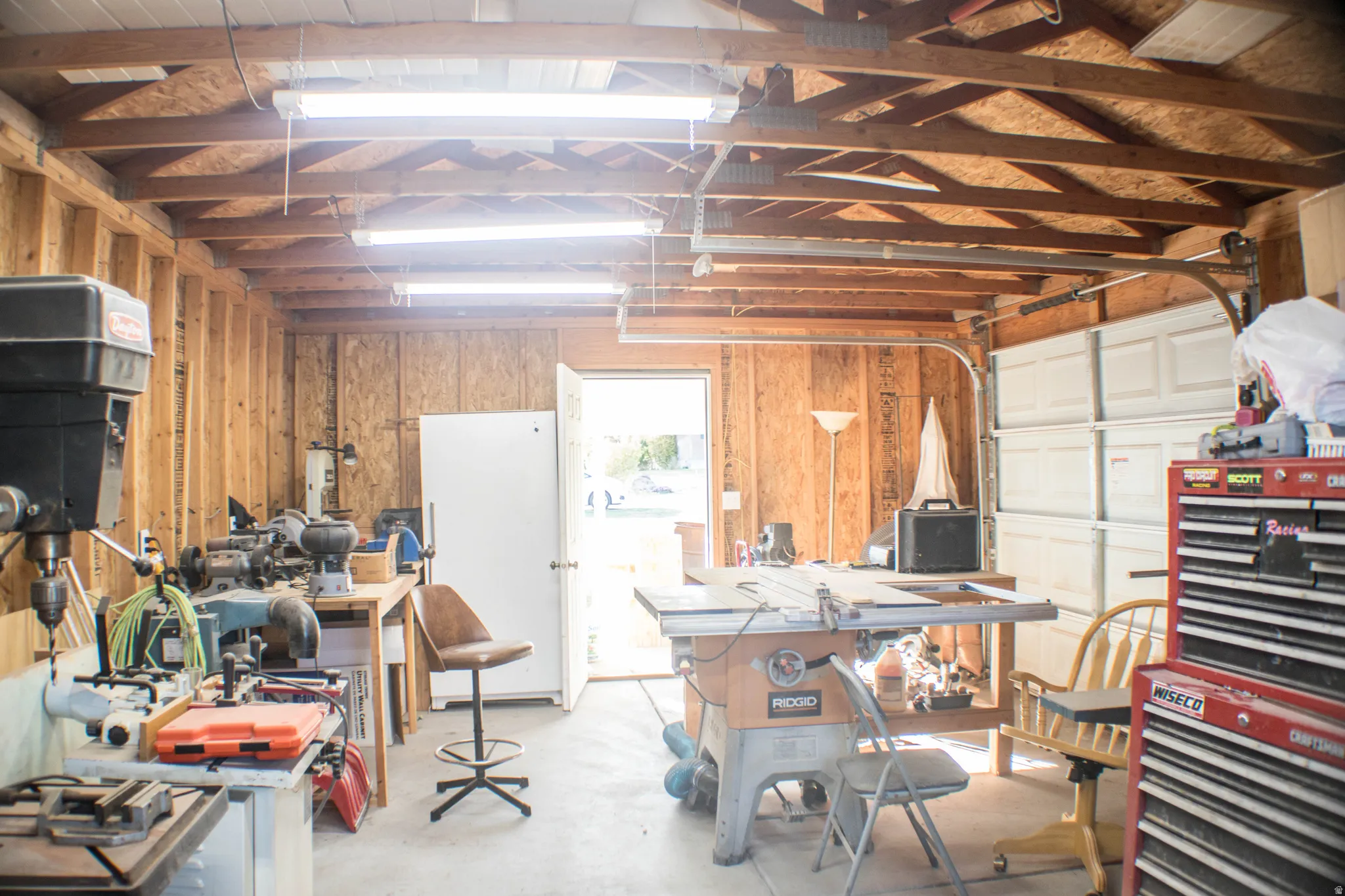 Garage with a workshop area and wood walls