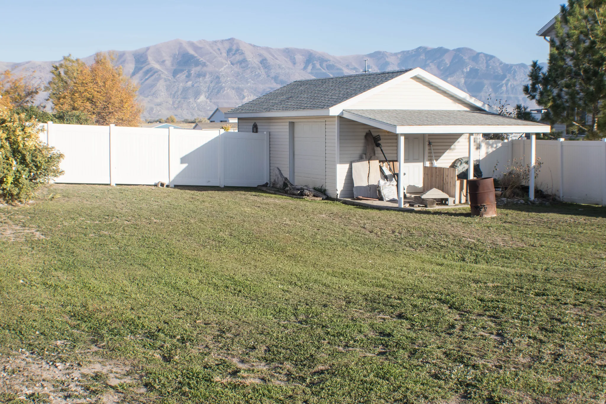 Fenced backyard featuring a mountain view, a patio, and a garage