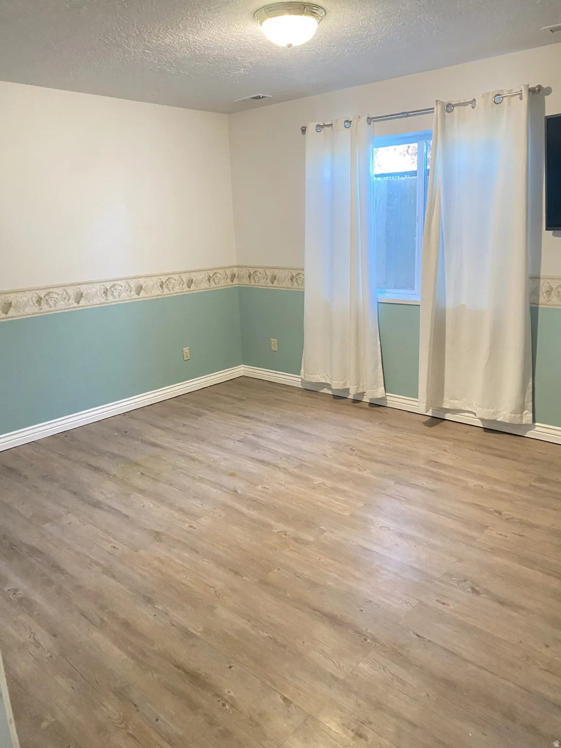 Unfurnished room featuring a textured ceiling and wood finished floors