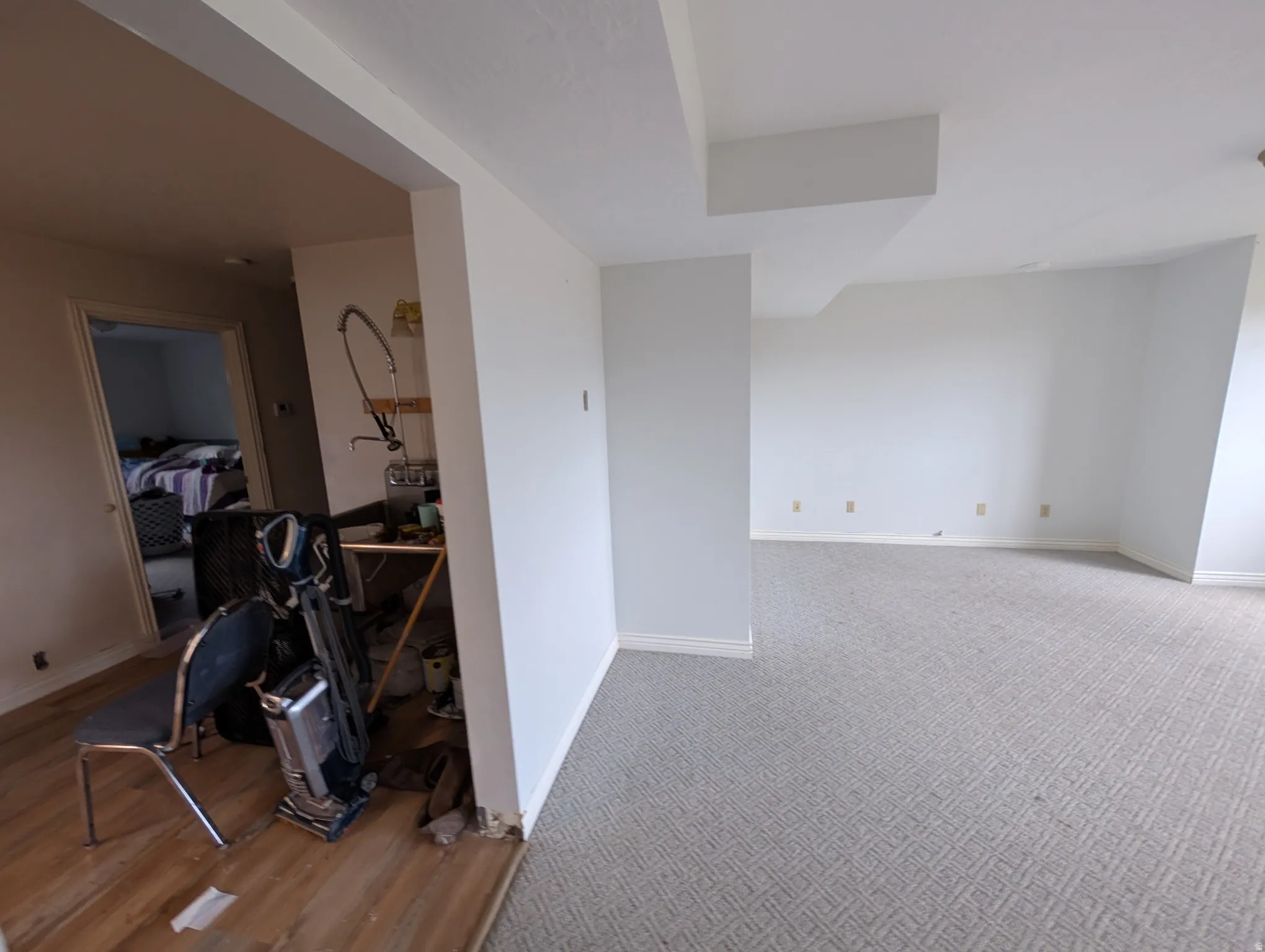 Carpeted spare room featuring baseboards