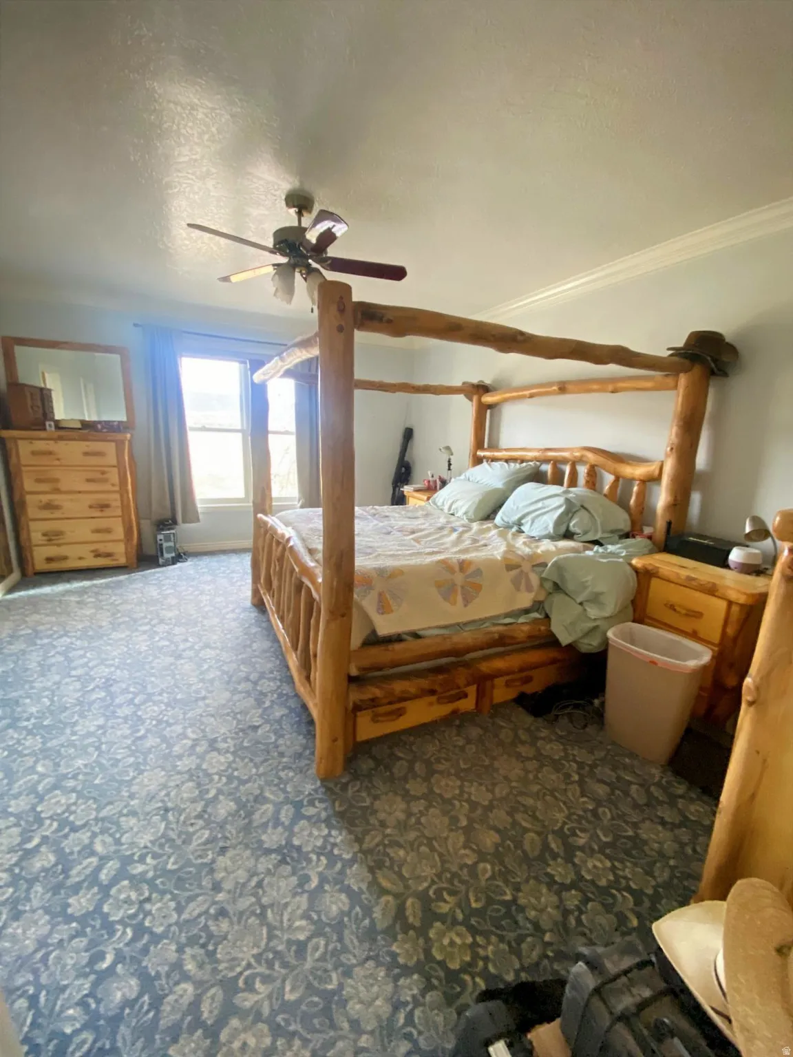 Bedroom featuring a textured ceiling, a ceiling fan, and carpet flooring