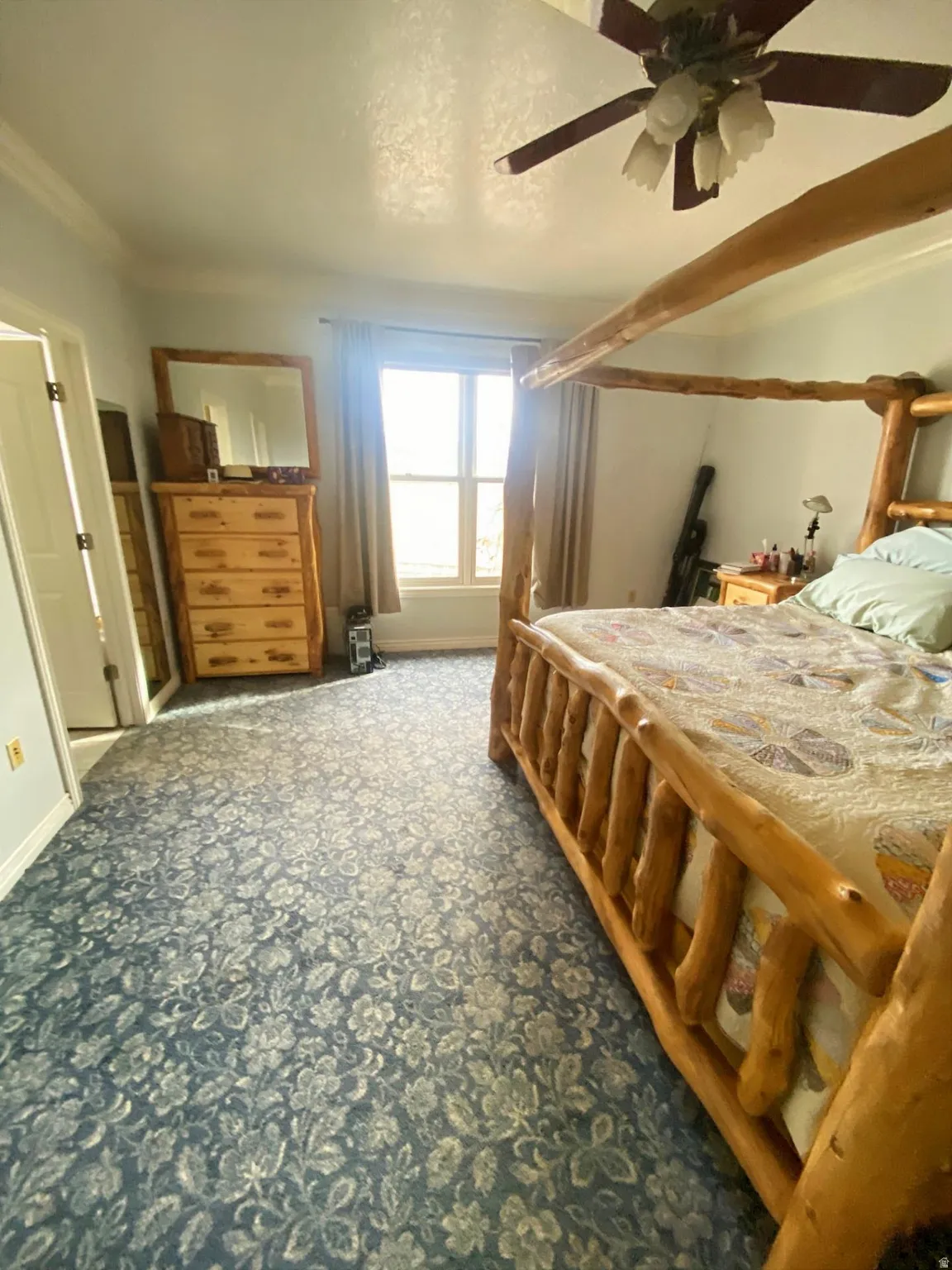 Bedroom with ceiling fan, carpet, and crown molding