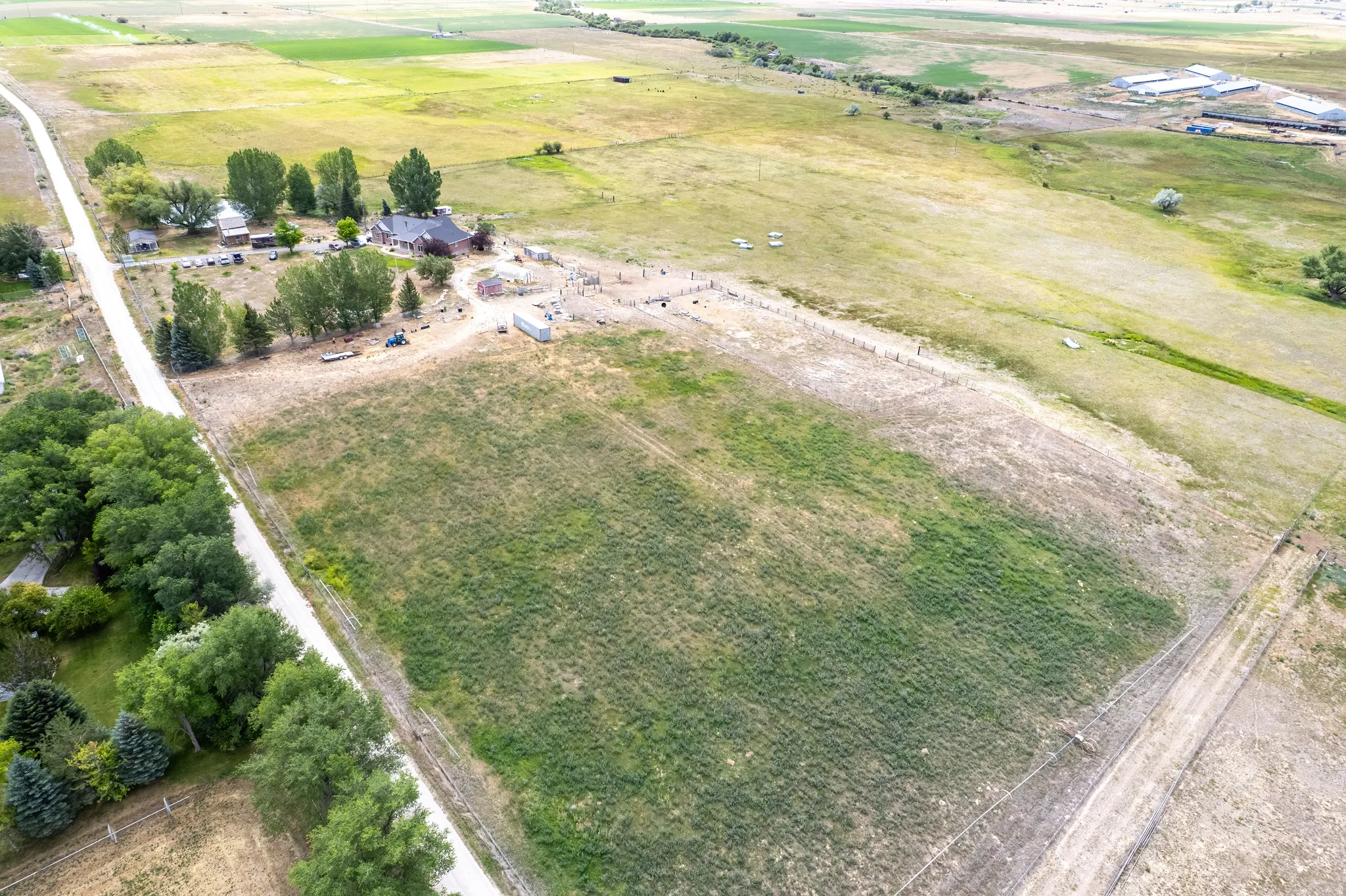 Extensive rural property featuring a main residence, multiple outbuildings, and expansive open fields