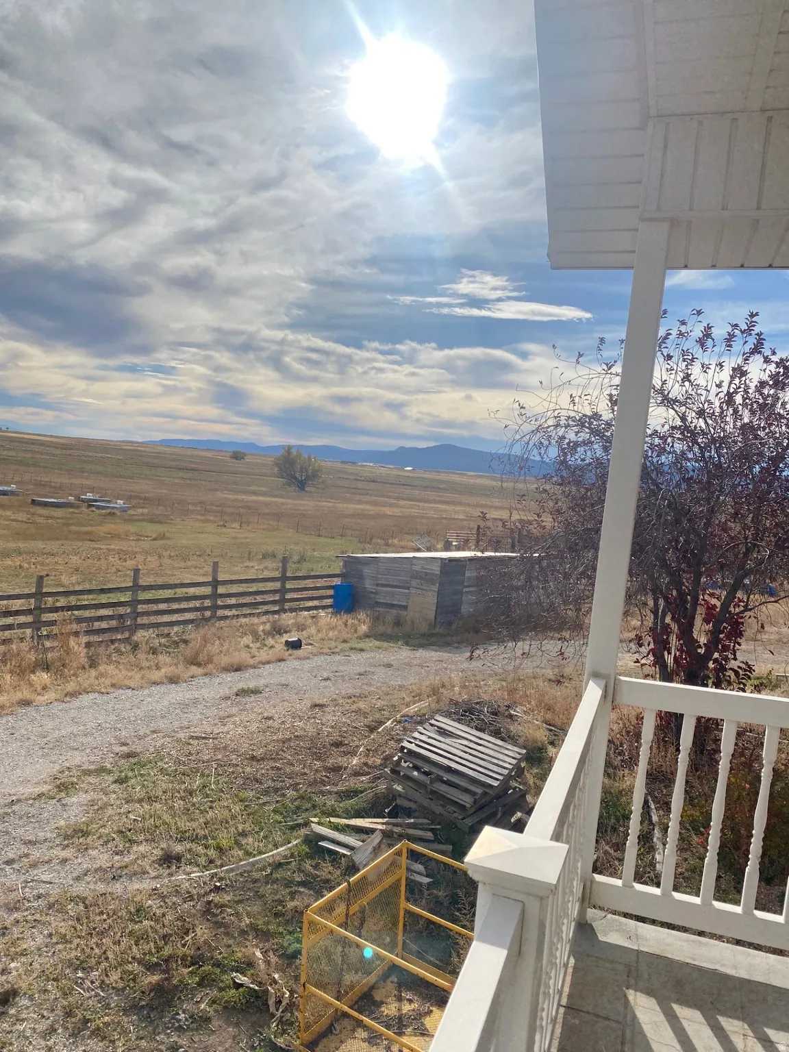 View of yard featuring a balcony and a view of countryside