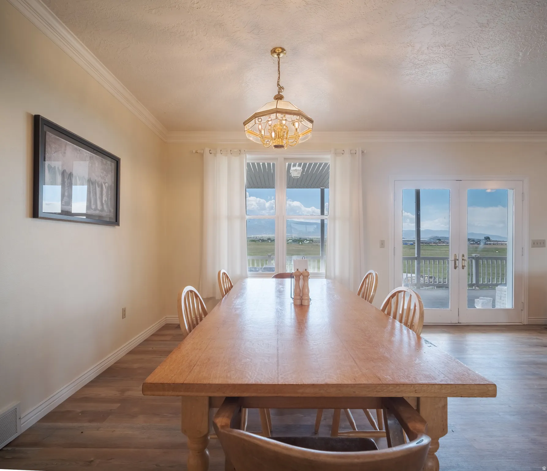 Dining area featuring wood-finish flooring and crown molding