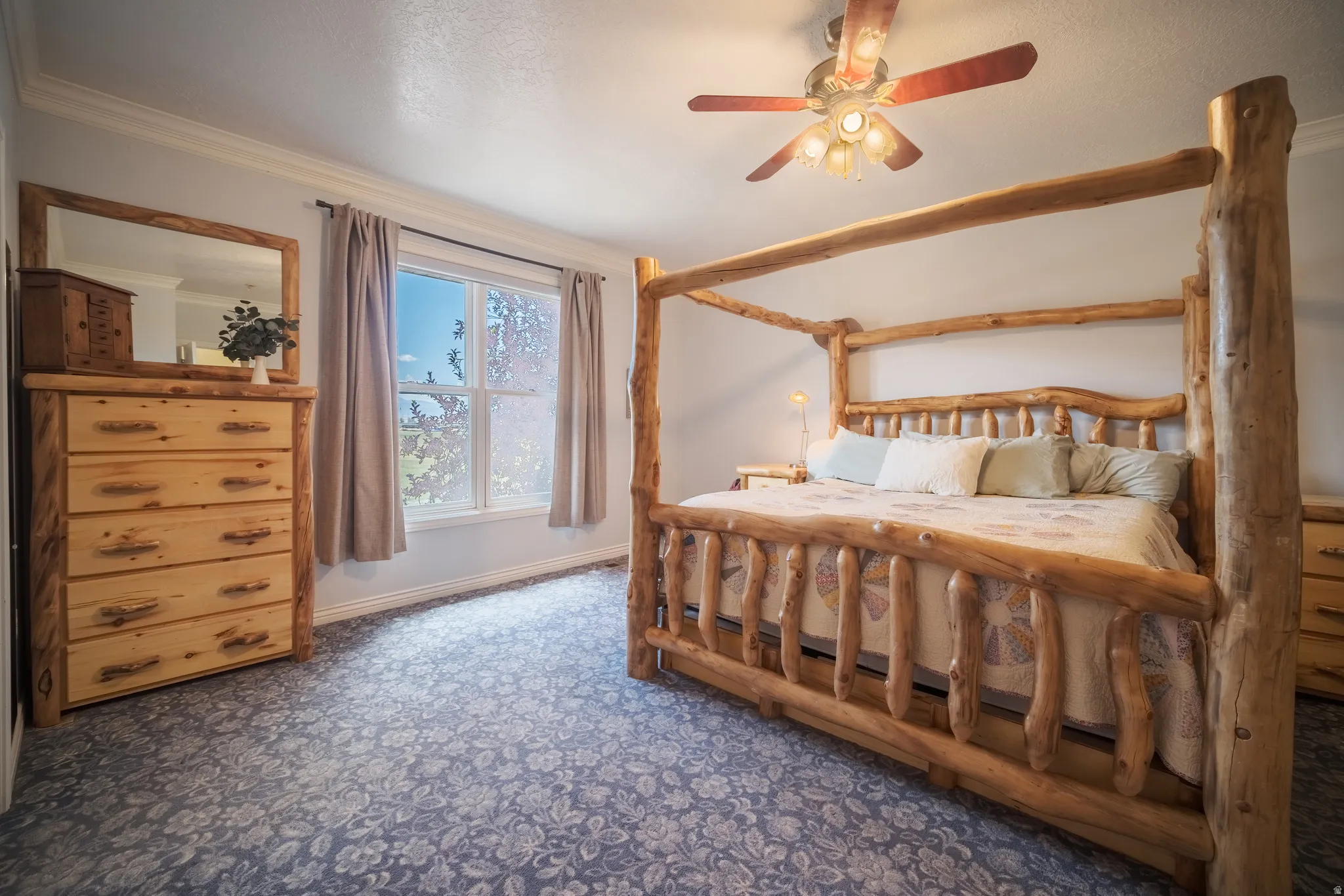 Spacious room featuring a patterned carpet, a ceiling fan with integrated lighting, and a large window