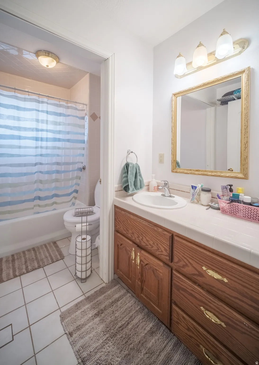 Bathroom featuring a vanity with wood cabinetry, a white countertop, and an integrated sink