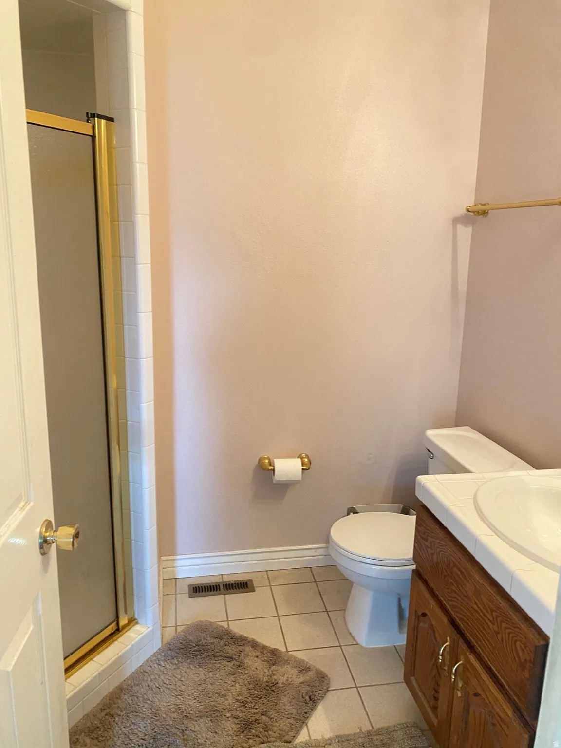 Bathroom featuring a shower stall, vanity, and light tile patterned floors