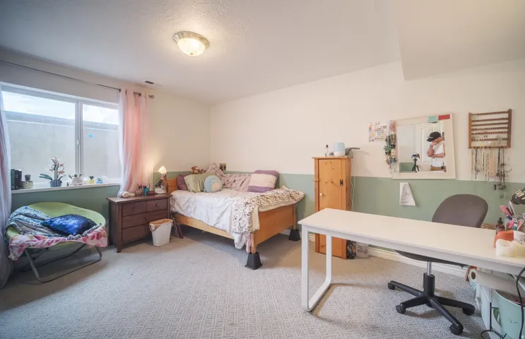 Bedroom featuring light-colored patterned carpeting and a white ceiling with a flush-mount light fixture
