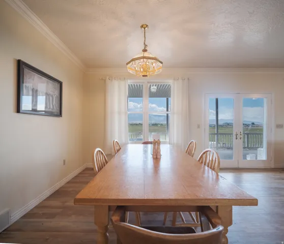 Dining area featuring wood-finish flooring and crown molding
