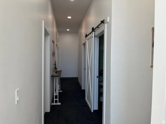 Hall featuring recessed lighting and a barn door