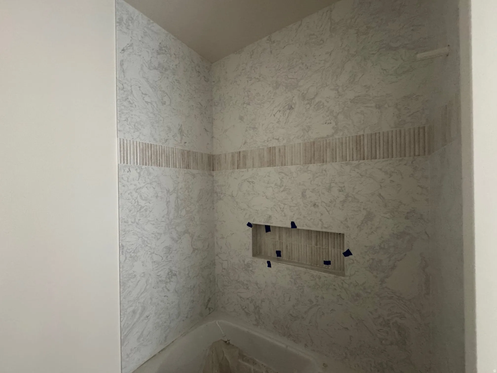 Bathroom featuring a combined bath / shower with marble appearance