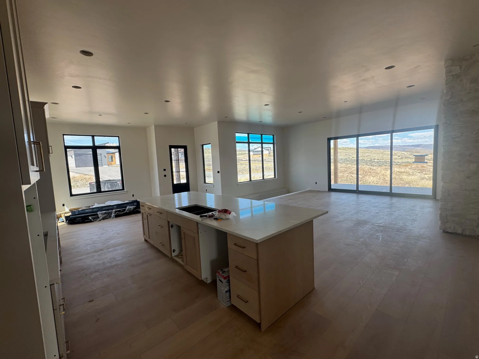 Kitchen featuring open floor plan, a center island, light wood finished floors, and light wood finish cabinetry