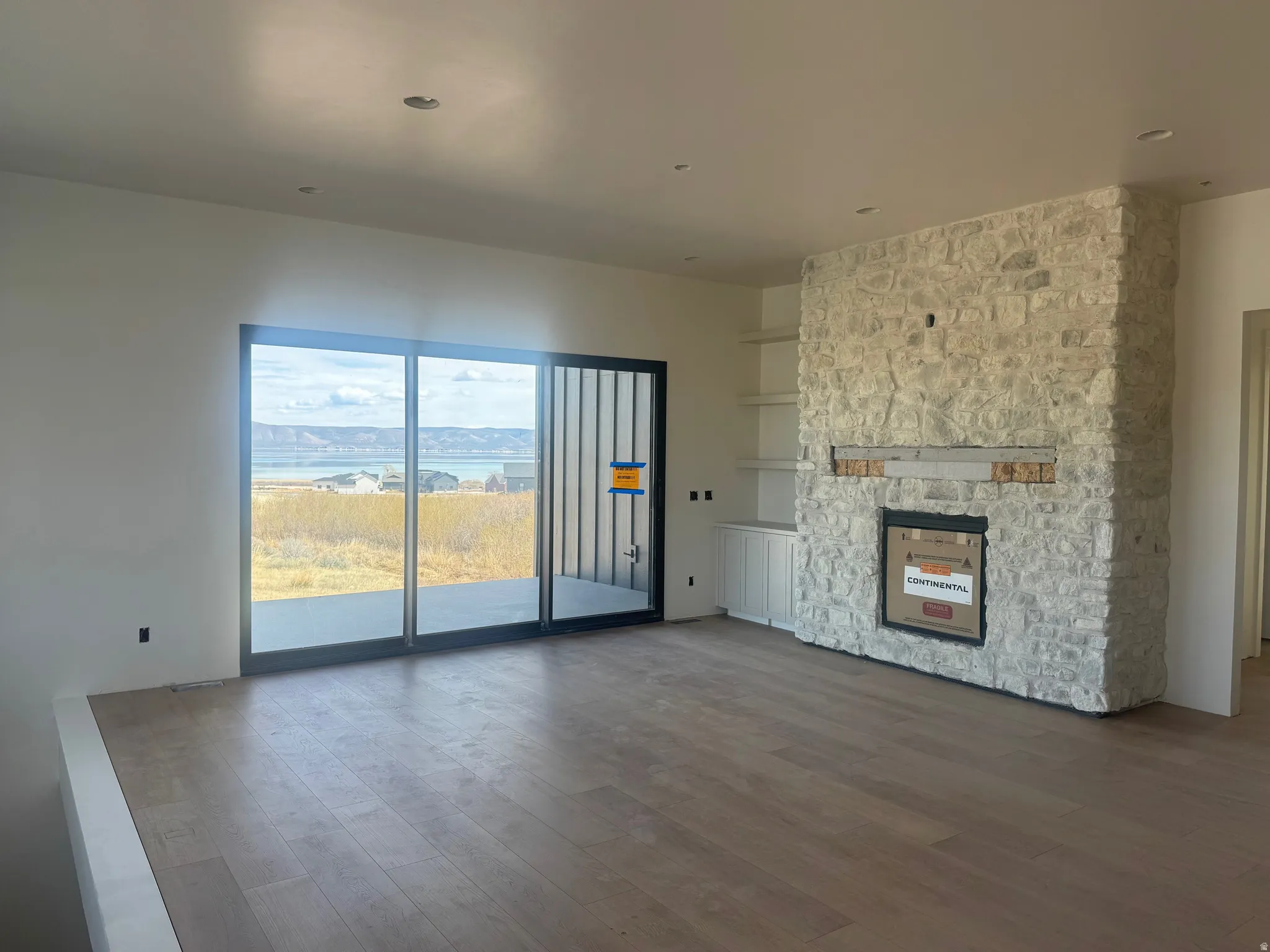 Unfurnished living room with dark wood-style flooring, a fireplace, and built in features