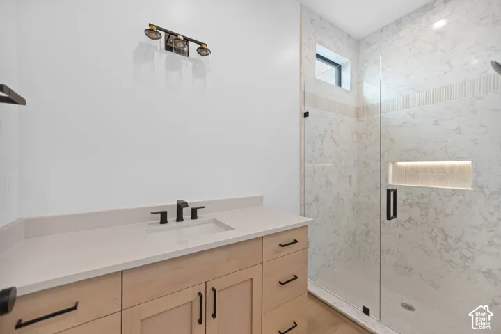 Light wood-finish vanity with an integrated sink and matte black fixtures