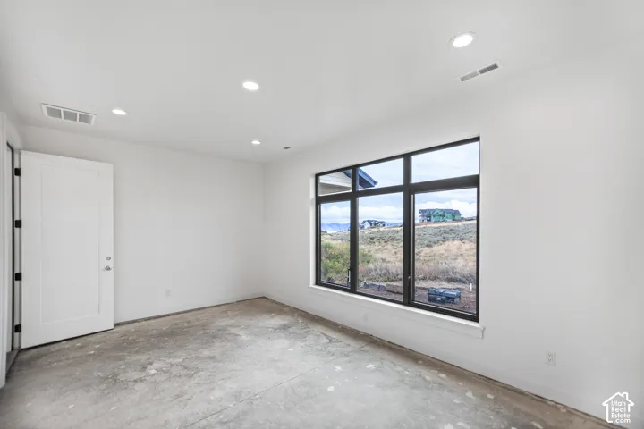 Large window with dark frames, recessed lighting, and a solid white door with dark hardware