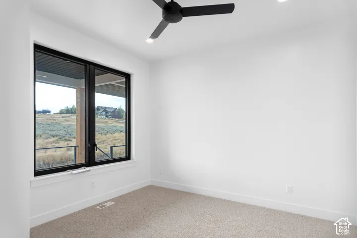 Recessed lighting, ceiling fan, and large window with dark trim