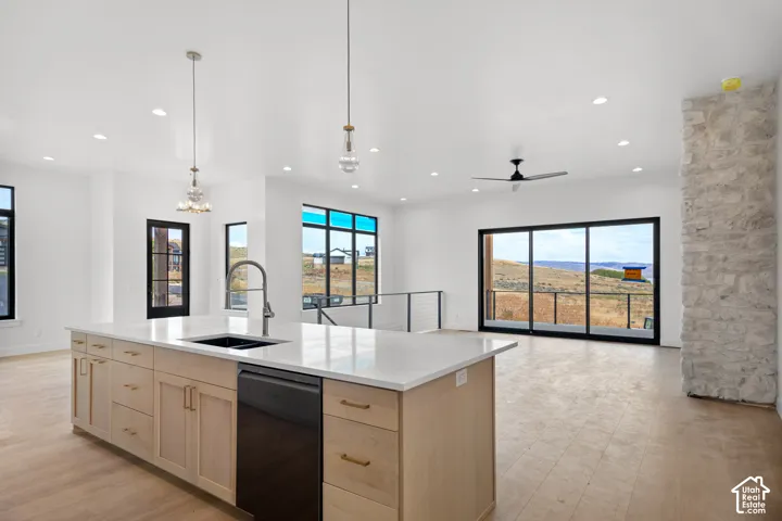 Kitchen island with light wood-finish cabinetry, white countertop, and integrated sink